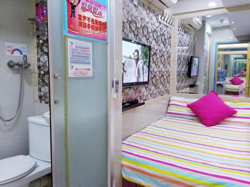 een kleine kamer met een bed en een toilet bij LongWin Hostel in Hong Kong