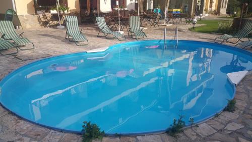 una grande piscina blu con sedie e tavoli di Hotel Via Trayana a Beli Osam