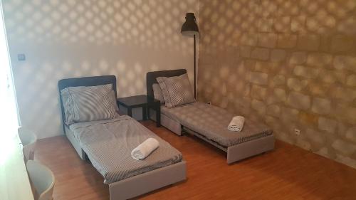 une chambre avec deux chaises, un lit et une lampe dans l'établissement Appartement quartier historique proche des Halles, à Tours