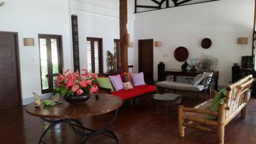 uma sala de estar com um sofá vermelho e uma mesa em Dapitan Beach Villa em Dapitan