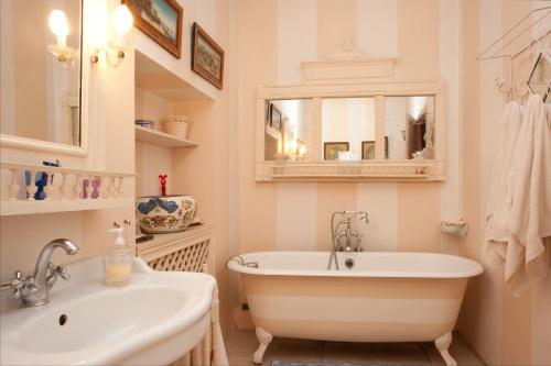 a bathroom with a tub and a sink and a mirror at Maison d'Hôtes Mas de Barbut in Saint-Laurent-dʼAigouze