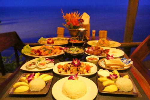 Una mesa con muchos platos de comida encima. en Amber Sands Beach Resort, en Ko Chang