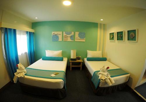 two beds in a room with green walls at Maayo Argao in Argao