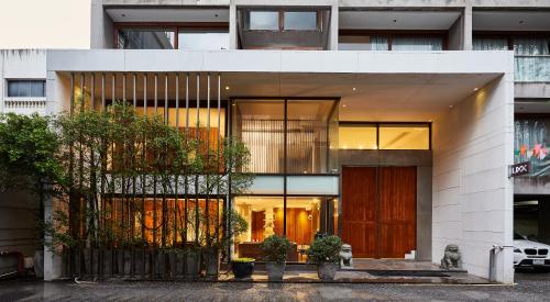 a large white building with windows and a door at LUXX Langsuan Hotel - SHA Plus in Bangkok