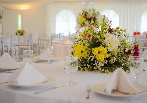 a white table with a centerpiece of flowers and glasses at Maayo Argao in Argao