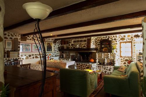 a living room with a table and green chairs at B&B Molino Del Gobbo in SantʼAgata Feltria
