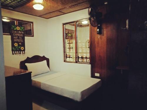 a small bed in a room with a window at BING-VICE Tourist Inn in San Vicente