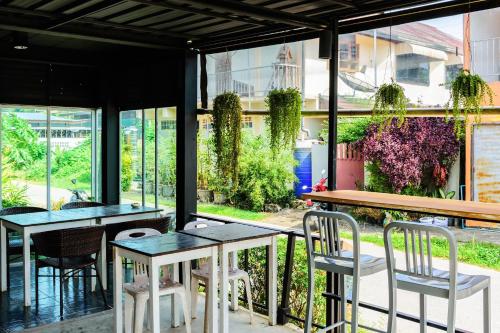 eine Terrasse mit 2 Tischen, Stühlen und Fenstern in der Unterkunft Loma Place in Ao Nang Beach