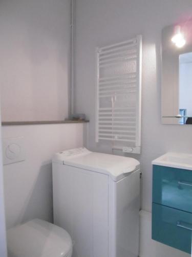 a white bathroom with a toilet and a sink at ECM Continental in Vittel