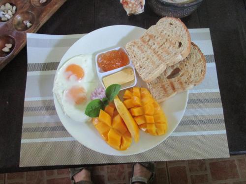 a plate of breakfast food with eggs and bread at Royal Cliff Resort in Siquijor