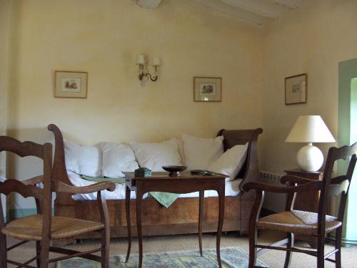 a living room with a couch and a table with chairs at Maison d'Hôtes Mas de Barbut in Saint-Laurent-dʼAigouze