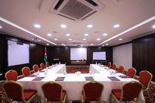 a large meeting room with a long table and chairs at City Rose Hotel Suites in Amman