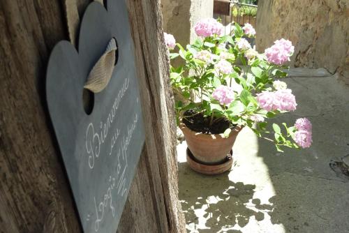 a sign on a door next to a potted plant at Le Logis d'Hortense in Vic-le-Comte