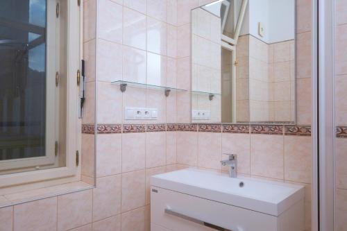 W łazience znajduje się biała umywalka i lustro. w obiekcie Pawlansky Apartments w Pradze