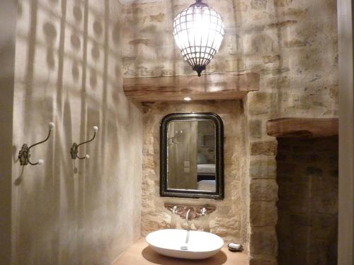 W łazience znajduje się umywalka i lustro. w obiekcie Le Logis d'Hortense w mieście Vic-le-Comte