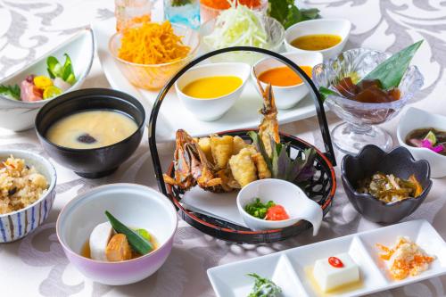 a table with many bowls of food on it at EN RESORT Kumejima EEF Beach Hotel in Kumejima
