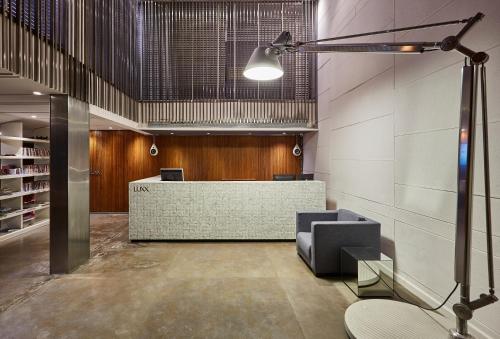 a lobby with a reception desk in a building at LUXX Langsuan Hotel - SHA Plus in Bangkok