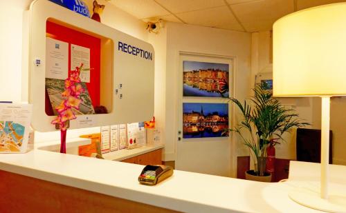an office with a reception desk with a lamp at ibis budget Honfleur Centre in Honfleur