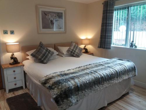 a bedroom with a bed with a blanket on it at The Stables - Deer Park Farm in Solihull