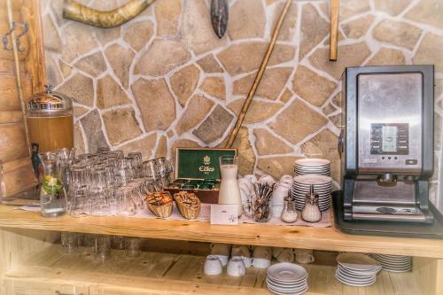 a shelf with dishes and a coffee machine on it at Hotel Koliba Greta in Liptovská Sielnica
