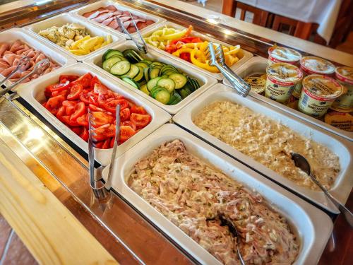 a buffet filled with different types of vegetables in trays at Hotel Koliba Greta in Liptovská Sielnica