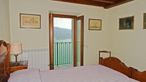 a bedroom with a bed and a view of a balcony at Casa De Pol Exclusive Lake View by Gardadomusmea in Tremosine Sul Garda