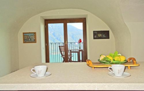 a table with two cups and a bowl of fruit at Casa De Pol Exclusive Lake View by Gardadomusmea in Tremosine Sul Garda