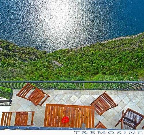 a view of the ocean from a balcony with chairs and tables at Casa De Pol Exclusive Lake View by Gardadomusmea in Tremosine Sul Garda