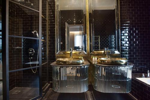 a bathroom with three sinks and a mirror at Sofia Boutique Residence in Yogyakarta