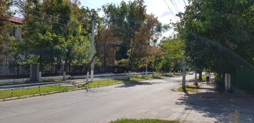 an empty street with trees on the side of the road at La Vitalie Guest House in Chişinău