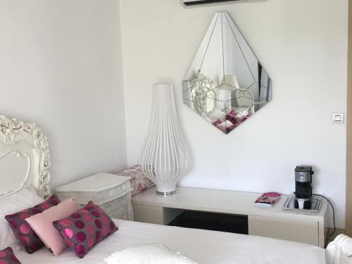 a bedroom with a bed and a desk and a mirror at Charmantes chambres 792 Route Inférieure de Cardo in Bastia