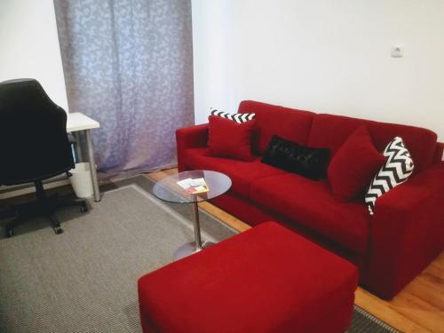 ウィーンにあるアパートメント ヴァサガッセのリビングルーム(赤いソファ、テーブル付)