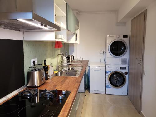 uma cozinha com uma máquina de lavar roupa e uma máquina de lavar e secar roupa em Urban Nest Apartment em Bucareste