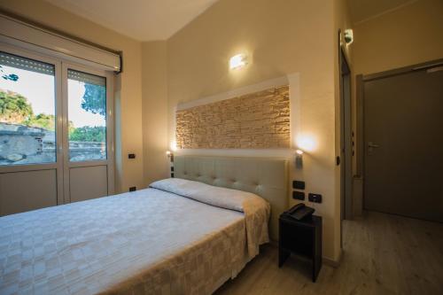 a bedroom with a bed and a large window at Hotel Calamosca in Cagliari