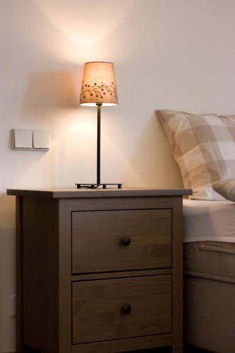 a lamp on a dresser next to a bed at Hotel Dvur Hoffmeister in Velké Číčovice