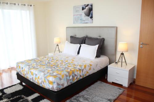 a bedroom with a large bed with two lamps at Hills and Atlantic Ocean retreat - Conceição House in Calheta