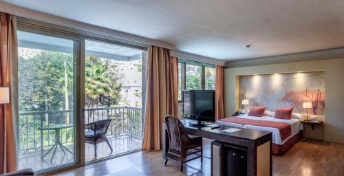a hotel room with a bed and a balcony at Hotel Colon Rambla in Santa Cruz de Tenerife
