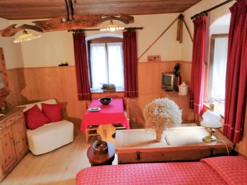 ein Wohnzimmer mit einem Sofa und einem Tisch in der Unterkunft Al Piz Monolocale in Colle Santa Lucia