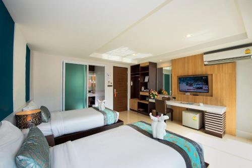 Habitación de hotel con 2 camas y escritorio en The Nice Krabi Hotel, en Krabi