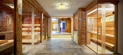 - un couloir avec des murs en bois et des portes en verre dans l'établissement Hotel Gletscherblick, à Sankt Anton am Arlberg