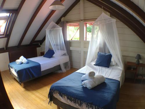 a room with two beds in a attic at Villa des Amandiers in Les Anses-dʼArlets