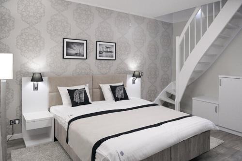 a bedroom with a large bed and a staircase at Willa Cicho Sza in Pobierowo