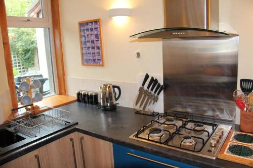 a kitchen with a stove top oven next to a window at Reay Street Apartment in Inverness