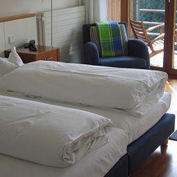 2 łóżka pojedyncze w pokoju z krzesłem i krzesłem w obiekcie Hotel Oberschwaebischer Hof w mieście Schwendi