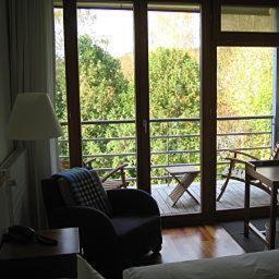 a living room with a chair and a large window at Hotel Oberschwaebischer Hof in Schwendi