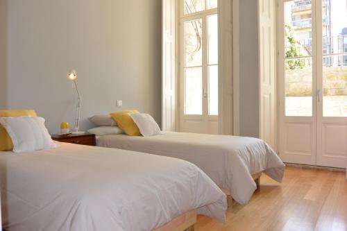 Habitación blanca con 2 camas y 2 ventanas en Casa Paillard, by Flat in Porto en Oporto