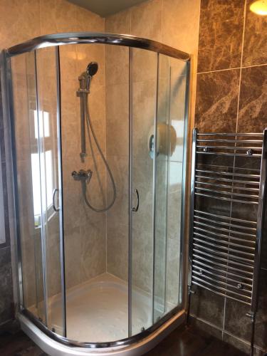 a shower with a glass door in a bathroom at Ely Guest House in Ely