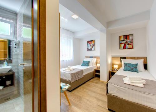a bedroom with two beds and a bathroom at Villa Floris in Mostar