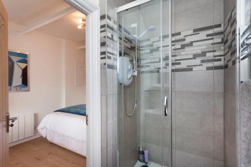 baño con ducha y puerta de cristal en Vale View Barn en Grantham