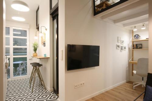 sala de estar con TV de pantalla plana en la pared en Moderno y reformado apartamento al lado del Museo, en Madrid